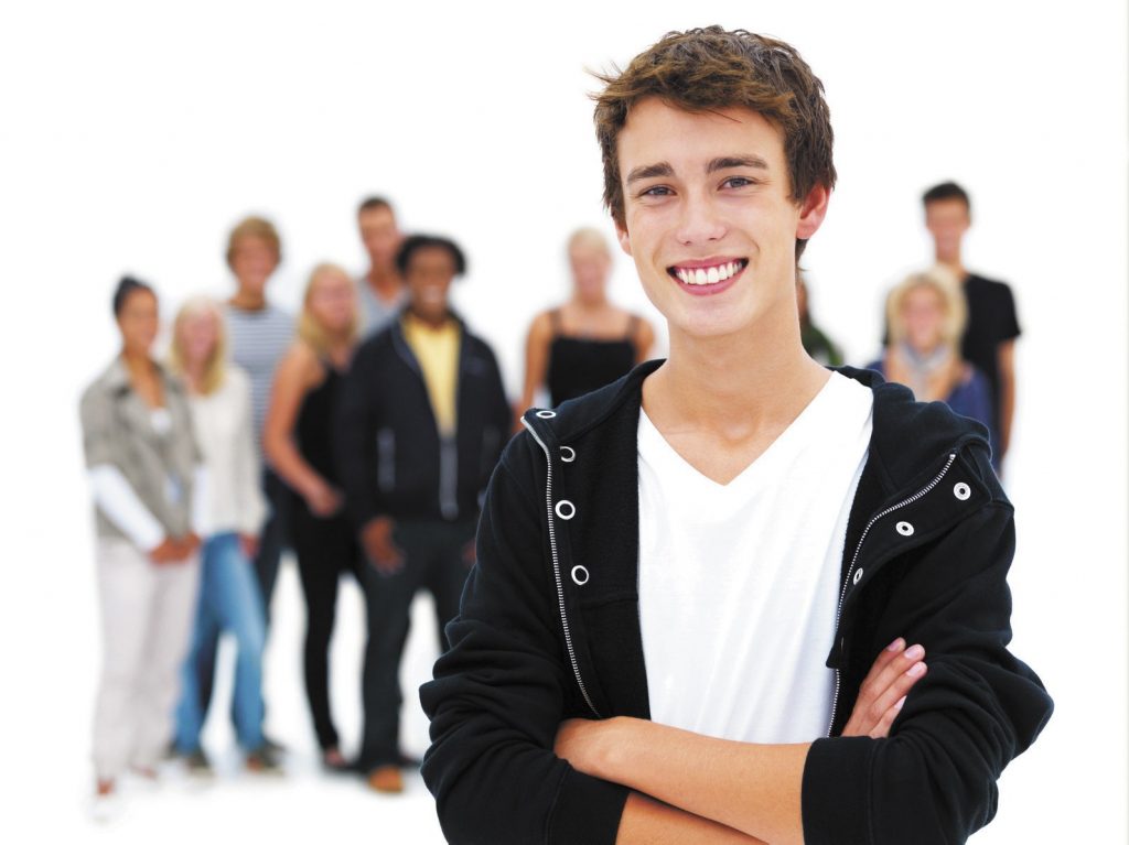 Happy young boy smiling with friends in the background